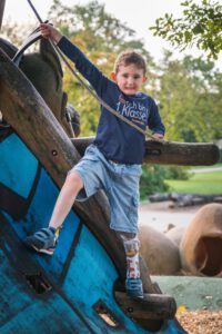 Kind mit Orthoplaste auf Klettergerüst, Image Kampagne für lokales Unternehmen