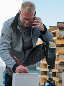 Mann bei körperlicher Arbeit auf der Baustelle mit Orthese. Image Kampagne für lokales Unternehmen